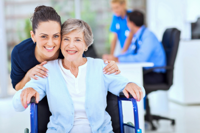 senior woman and caregiver smiling